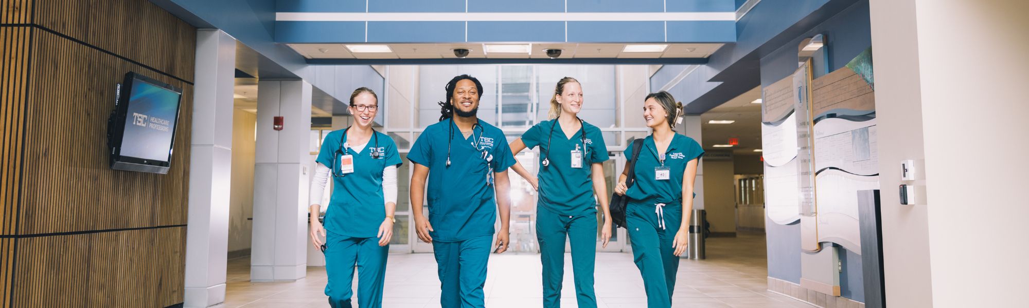 Four nursing students walking through the Ghazvini Center lobby.